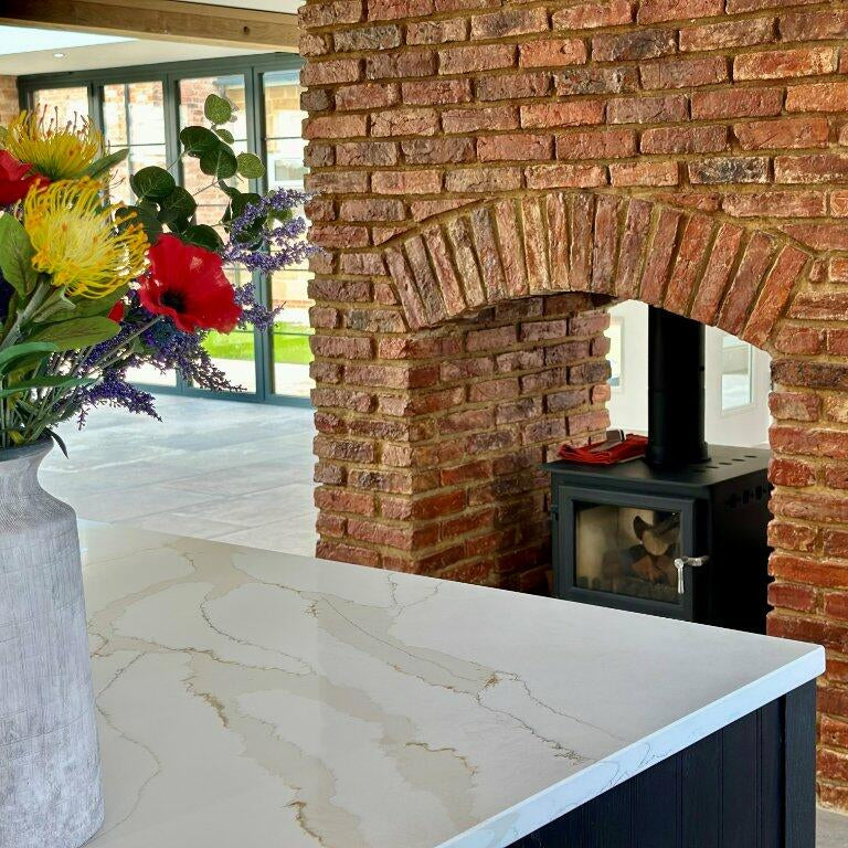 Exposed brick slip fireplace stove in home supplied and installed by heritage brick tile company