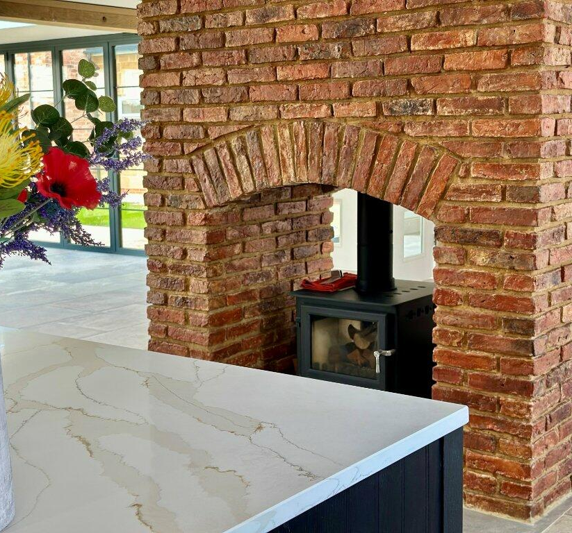 Exposed brick slip fireplace stove in home supplied by heritage brick tile company