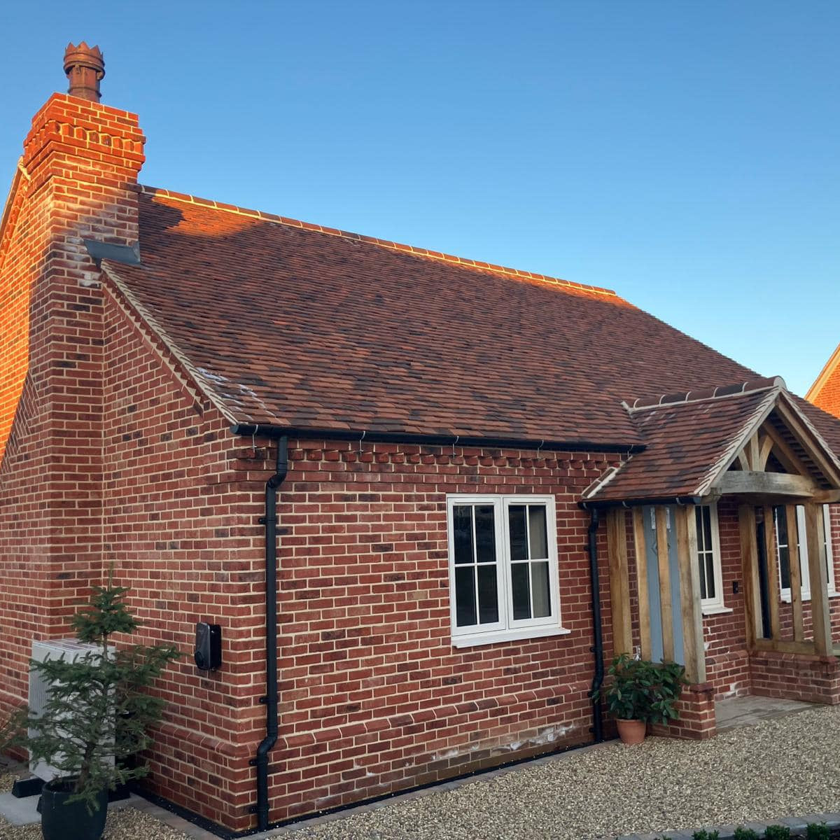 norfolk soft red rubber brick bungalow with bespoke weathered lay roof tiles
